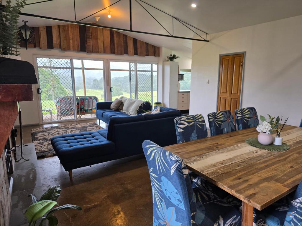 a living room with a blue couch and a wooden table at Hideaway Falls Rustic Farm House in Ravenshoe