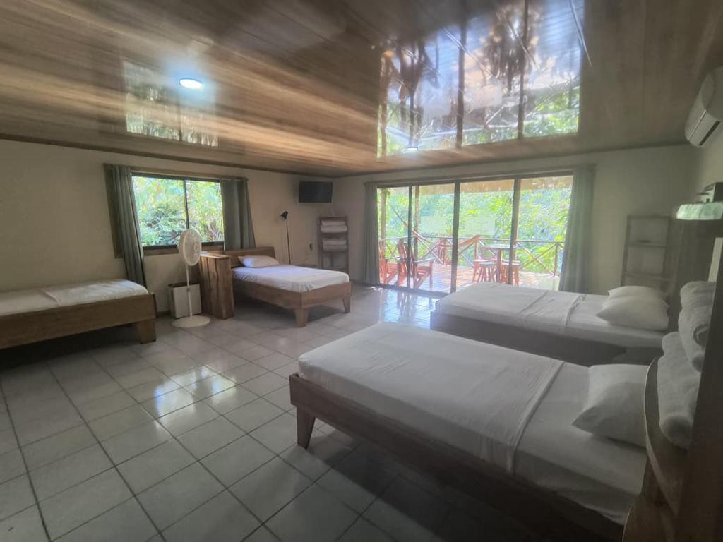 a large room with two beds and a room with at Drake Bay Corcovado The Monkey Trail in Drake