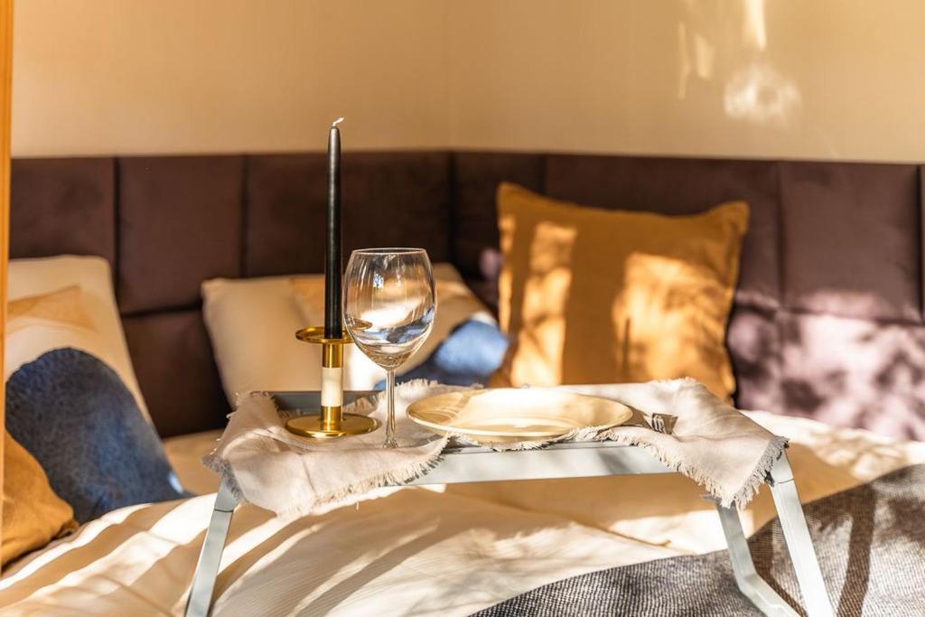 a table with a wine glass on top of a bed at Black Mirror inkl WLAN, Parkplatz Krankenhaus Detmold in Detmold