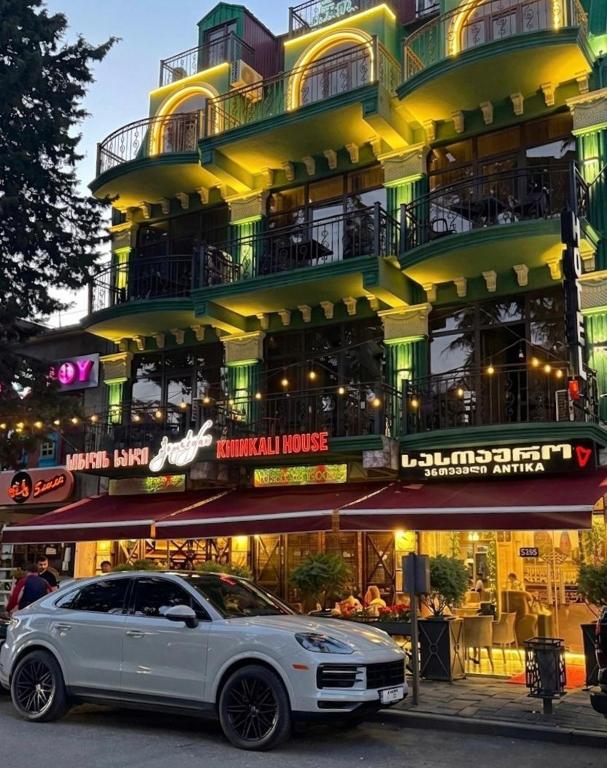 a white car parked in front of a building at Antika Hotel in Batumi