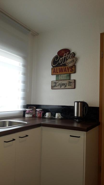 eine Küche mit Spüle und ein Schild an der Wand in der Unterkunft Apartment Lavendel nahe Polizeihochschule in Villingen-Schwenningen