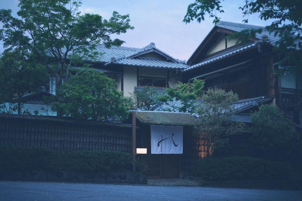a house with a fence with a painting on it at The Villa Higashiyama Roji Kazeno Heritage formaly HOTEL VMG VILLA KYOTO in Giommachi