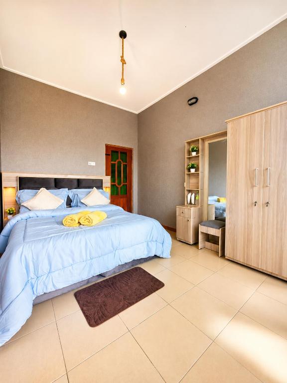 a bedroom with a large bed with a yellow blanket at Polo Region Rest Inn in Haputale
