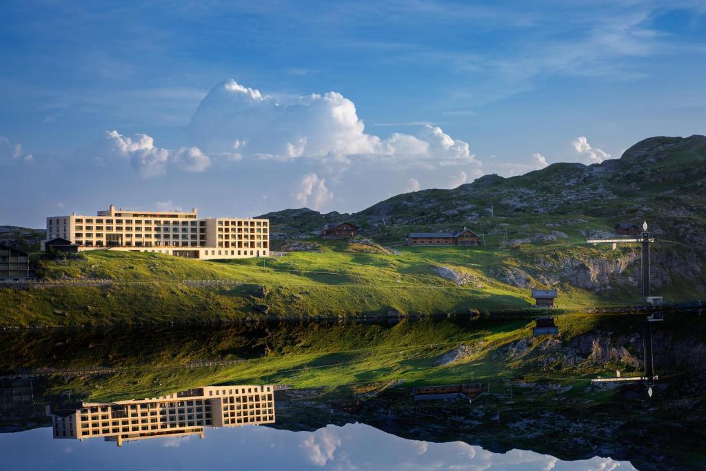 a building on a hill next to a body of water at Frutt Mountain Resort in Frutt