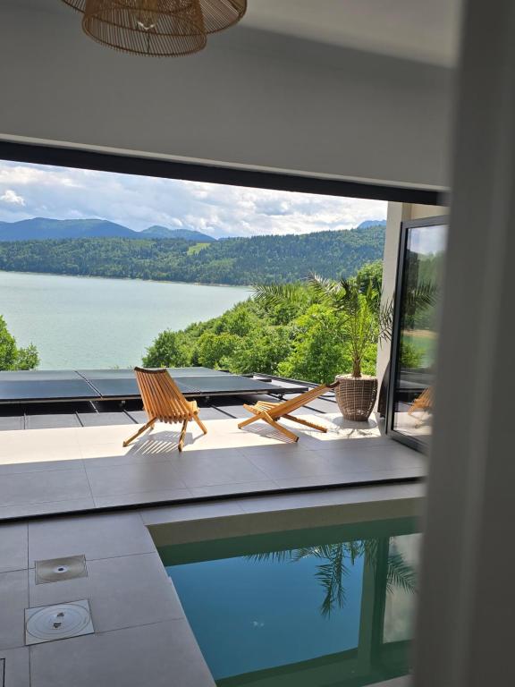 a house with a pool and a view of the water at Moon Lake Bicaz - Aurora Sky in Buhalniţa
