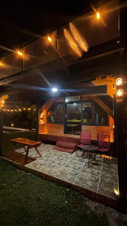 a patio with a table and chairs at night at Cluster Romantic Superior in Cicadas