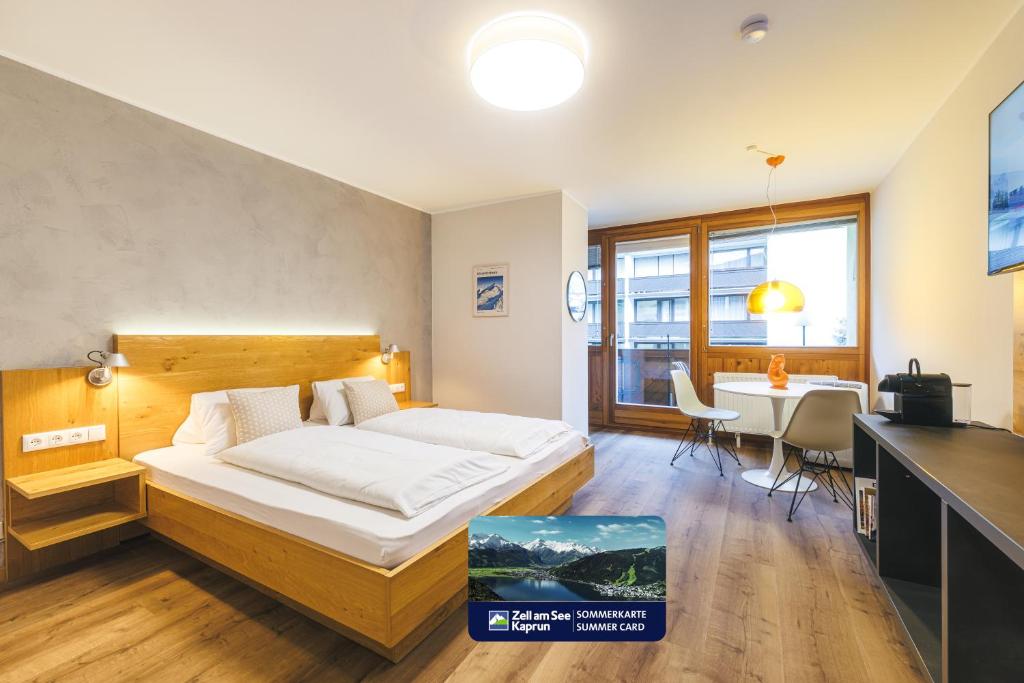 a bedroom with a bed and a table and a dining room at Studio 28 Kaprun inkl Sommerkarte in Kaprun