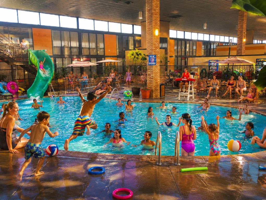 a group of children playing in a swimming pool at Wyndham Garden OKC Airport - Event Center, Indoor pool, Arcade Near Paycom, Fairgrounds in Oklahoma City