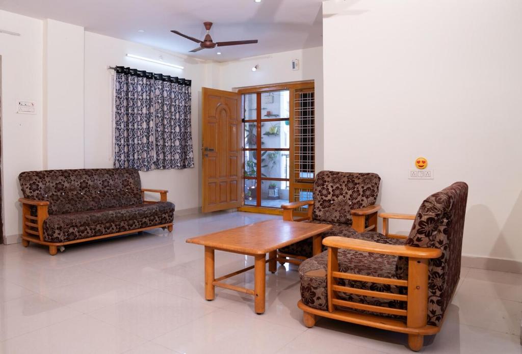 a living room with two chairs and a table at My3 Dwarkamai in Vijayawāda