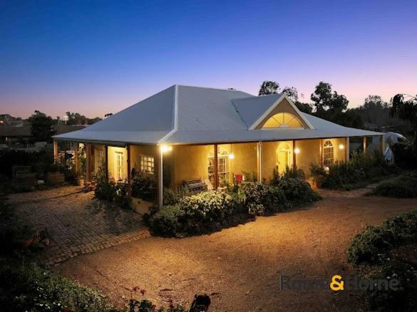 a large house with lights on in a yard at Strawbale House Bacchus Marsh in Bacchus Marsh