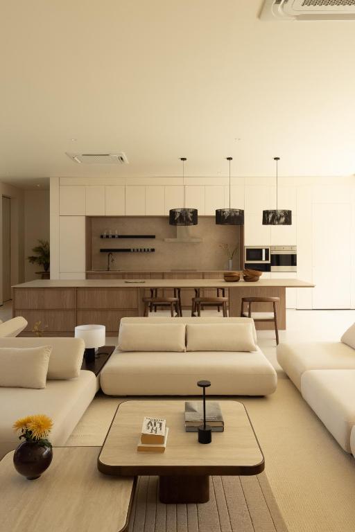 a living room with two white couches and a kitchen at KW3 Villas in Mae Nam