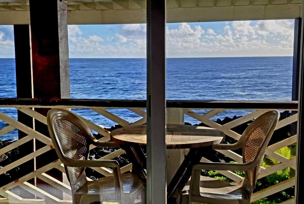 a table and chairs on a porch overlooking the ocean at Oceanfront studio see whales and dolphins in Pahoa