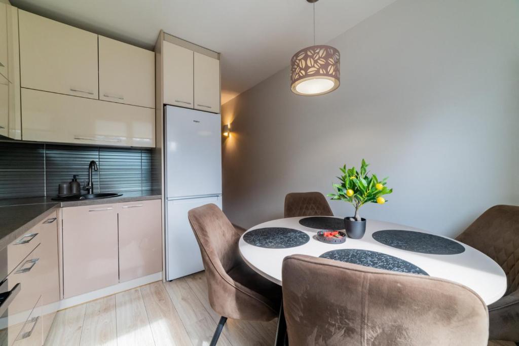 a kitchen and dining room with a table and chairs at VakarDi Apartments in Šiauliai