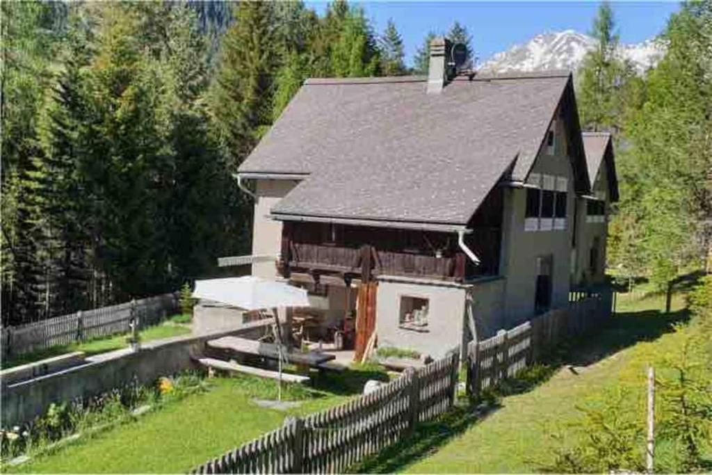 a house with a fence in front of it at Carolina Gatekeeper's House in Zernez