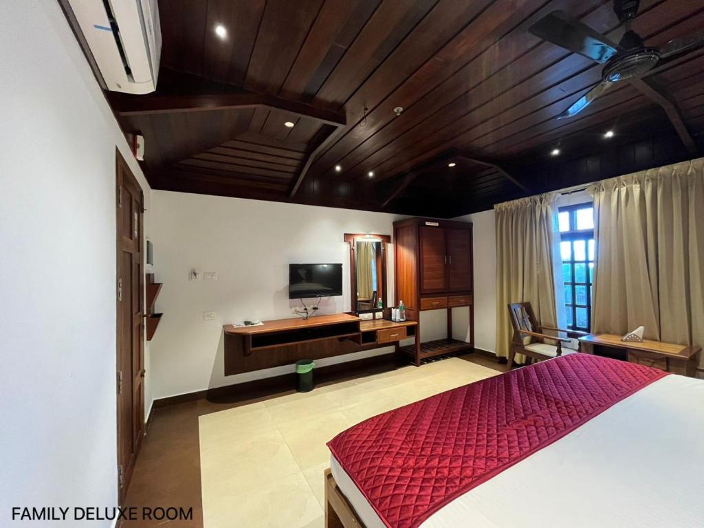 a bedroom with a bed and a television in it at Cherai Beach view Heritage in Pallipuram