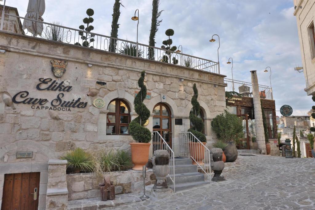 a building with a sign on the side of it at Elika Cave Suites Cappadocia, Curio Collection by Hilton in Ortahisar