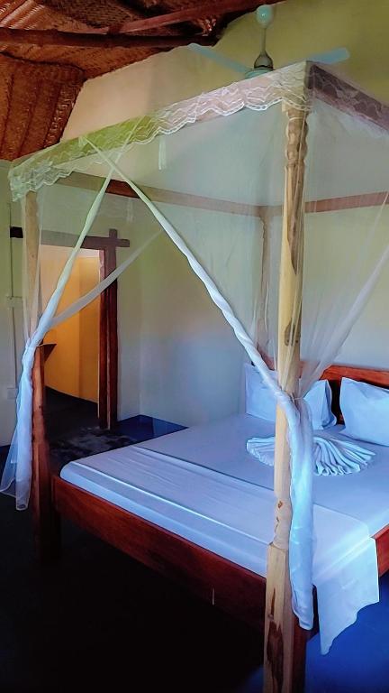 a bed with a canopy in a room at Nanakizilodge in Mtendeni