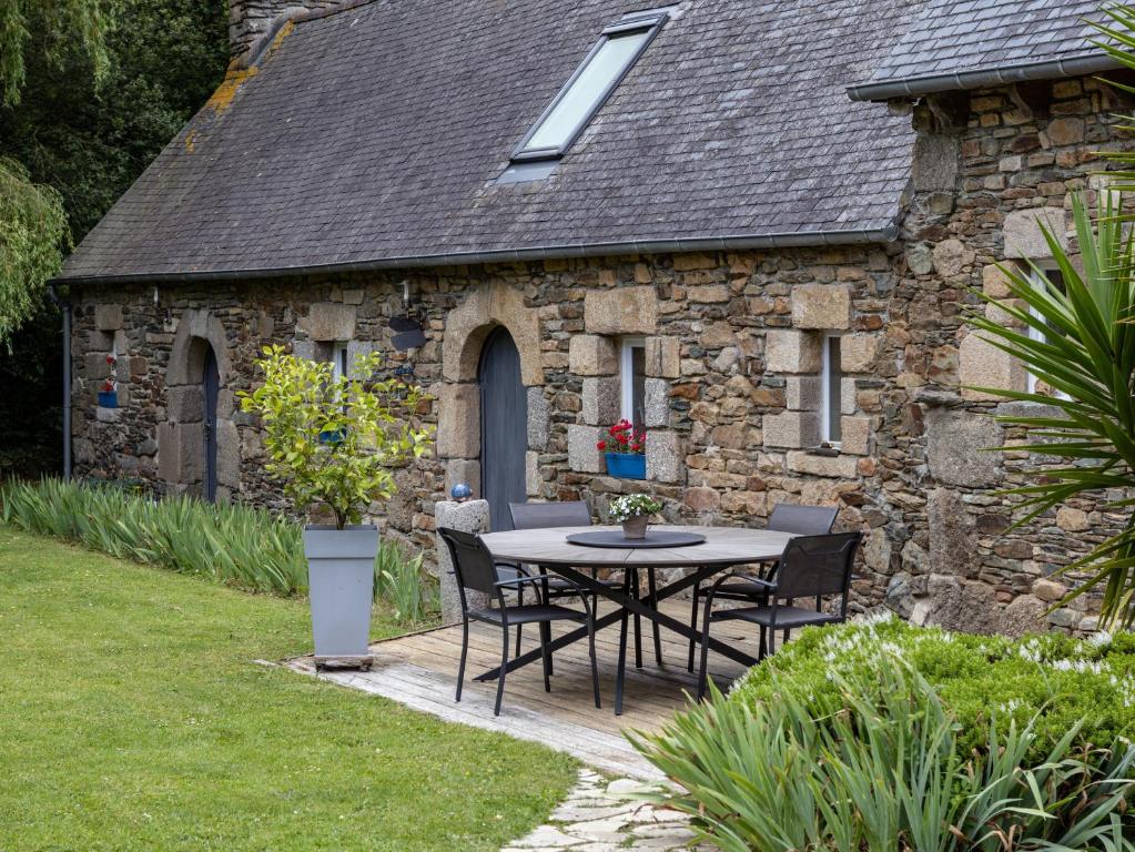 a table and chairs in front of a stone house at Escapade Bretonne in Lannion