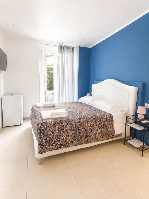 a bedroom with a large bed with a blue wall at Adam Eric in La Spezia