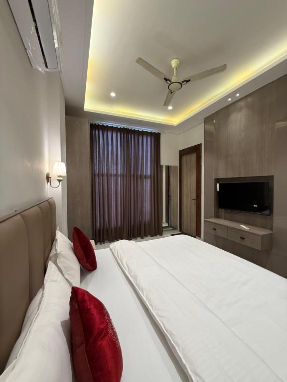 a bedroom with a large white bed with red pillows at Hotel sky inn in Jalandhar