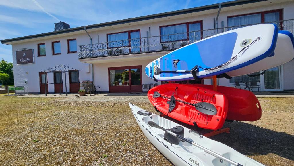 a group of surfboards and a kayak on top of a house at boardinghouse Kappeln by team SchleiFee - Studio Apartments mit Pantryküche in Kappeln