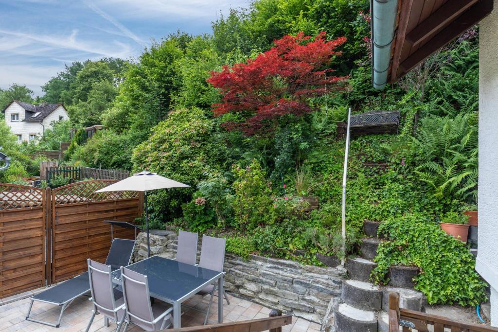 a table and chairs on a patio with a garden at Auszeit im Grünen in Bad Schwalbach