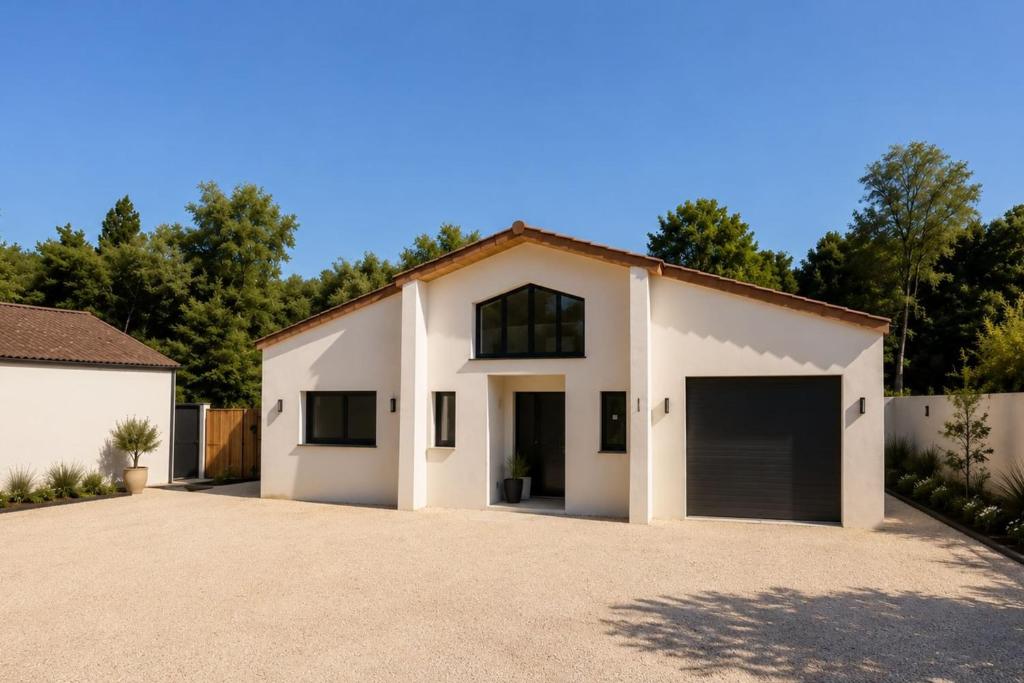 a house with two garage doors in a driveway at La Villa Andromède 10pers in Martillac