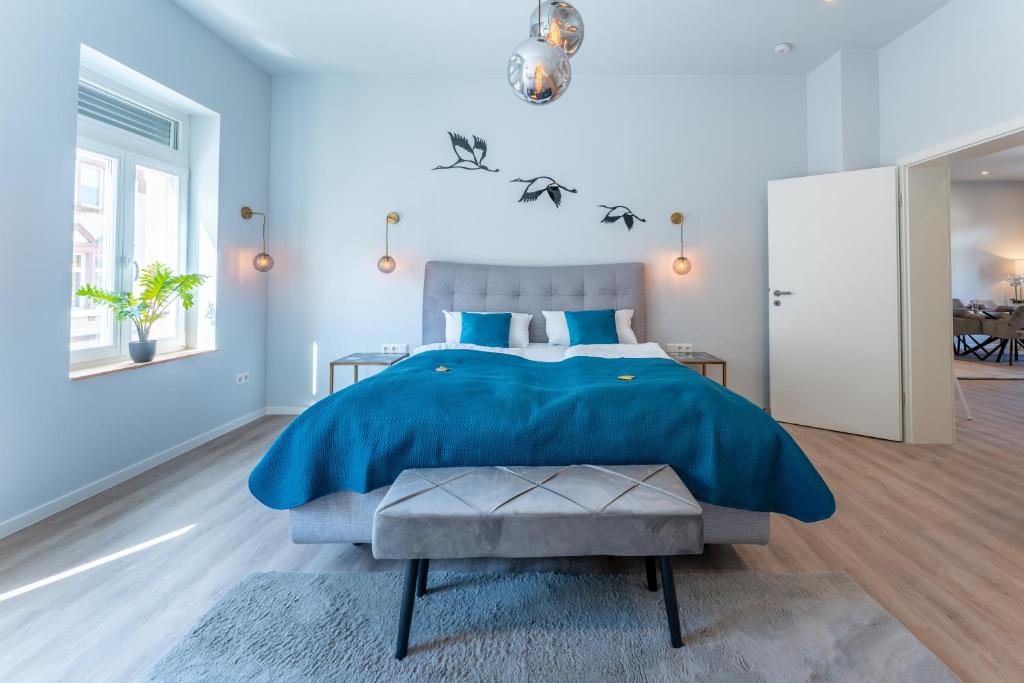 a bedroom with a blue bed with a blue comforter at Lit Living - Deluxe Apartments - Box Spring - Parking - Neueröffnung - NEW OPENING in Worms