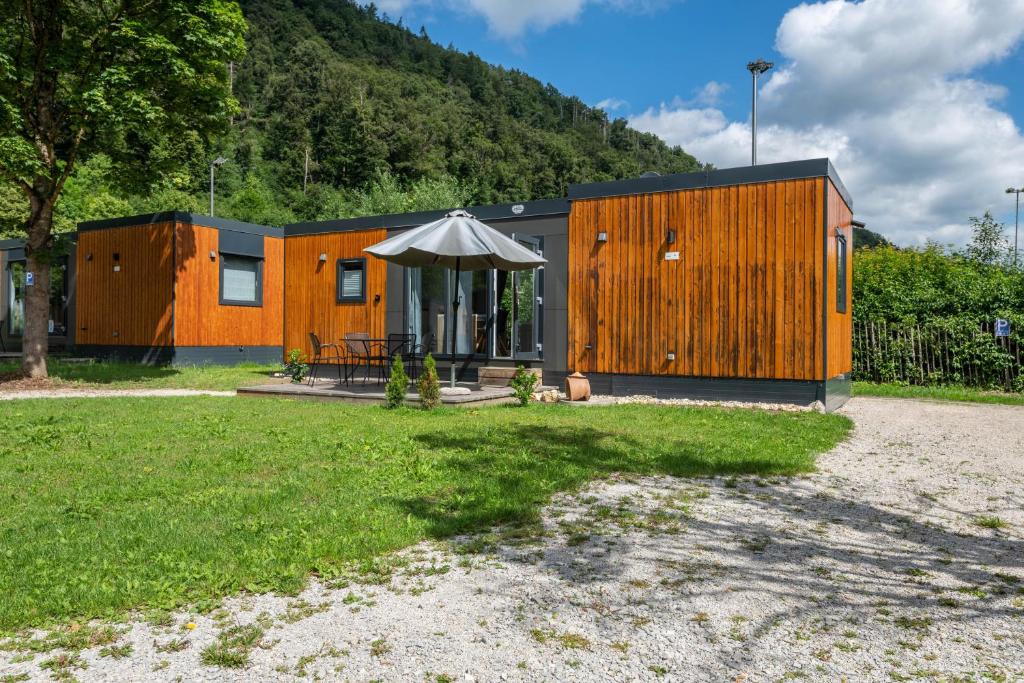 a cabin with a table and an umbrella in a yard at Holiday Home Tiny Haus Sunside in Riedenburg
