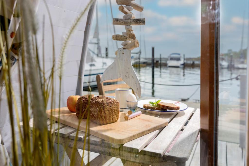 a table with bread and a plate of food on a boat at Hausboot Dotterbart in Stralsund