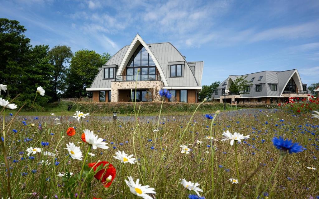 ein Haus mit einem Blumenfeld davor in der Unterkunft Scape Residences in Den Burg