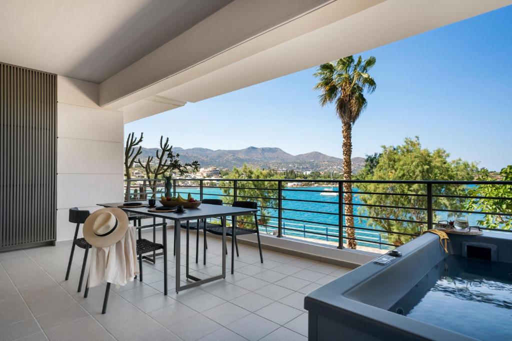 a balcony with a table and a bath tub at Urban Heights Ammoudi Seafront in Agios Nikolaos