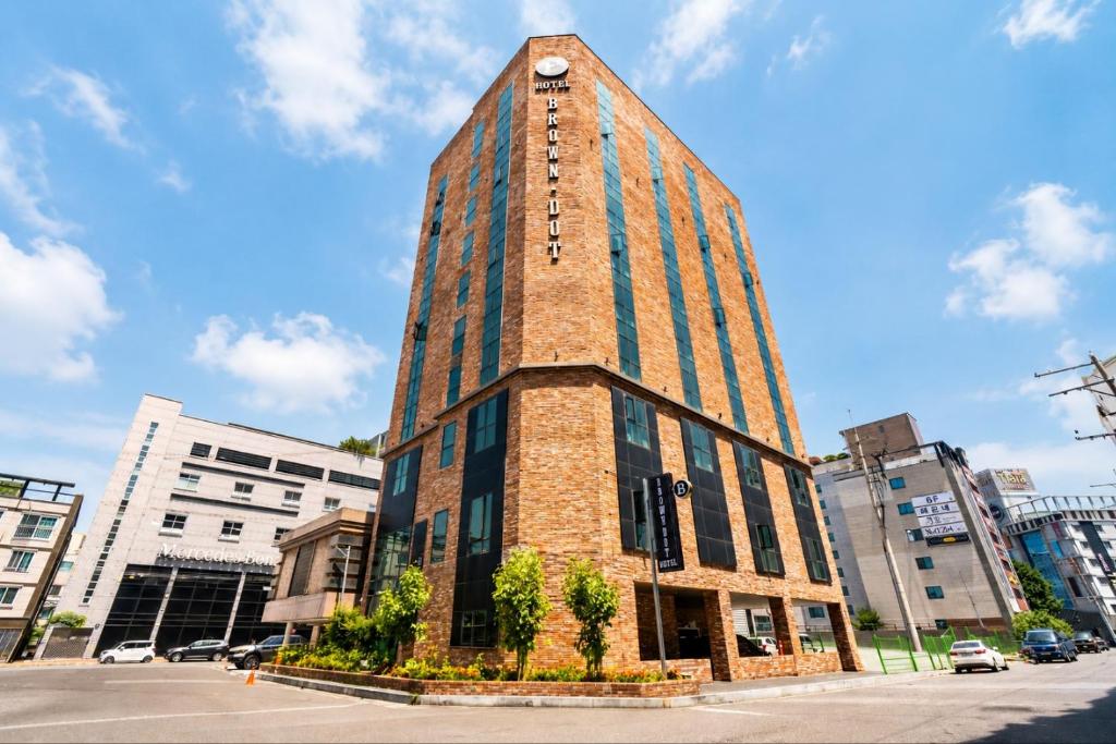 a tall brick building with a clock on top of it at Brown Dot Hotel Ulsan Samsan in Ulsan