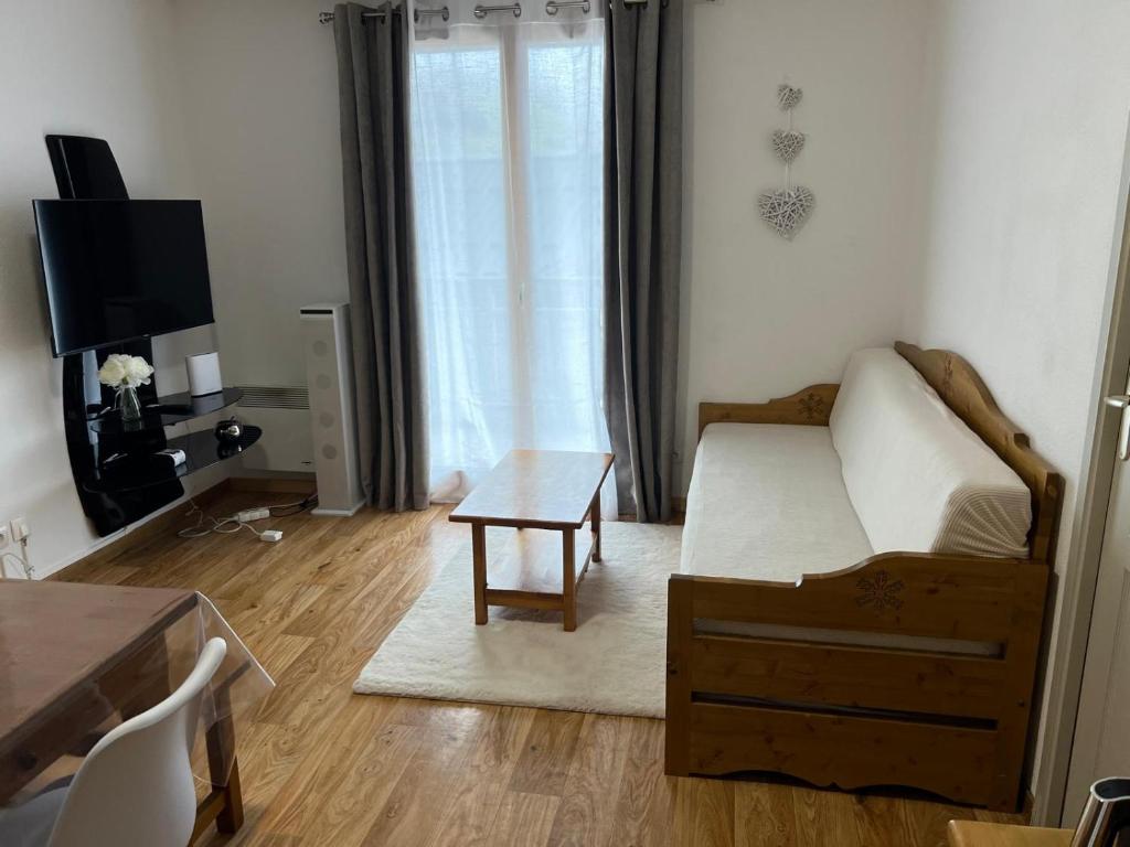 a living room with a couch and a table at Bel appartement montagne in Albiez-Montrond