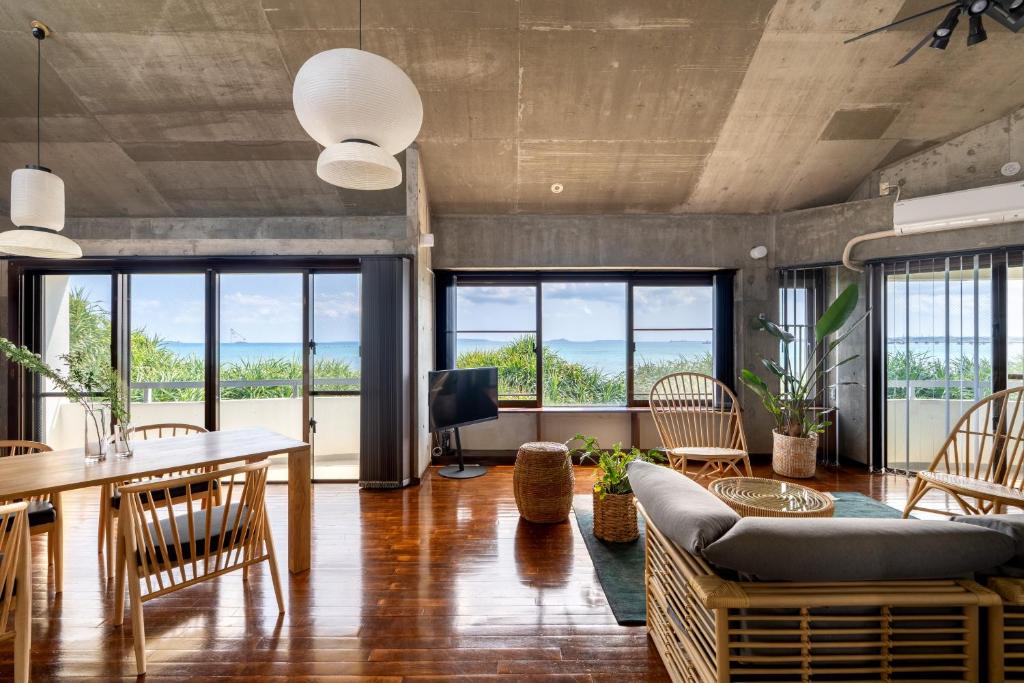 a living room with a couch and a table at Alumina アルミナ in Kin