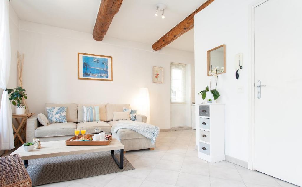 a living room with a couch and a table at Pimms Apartment in Antibes