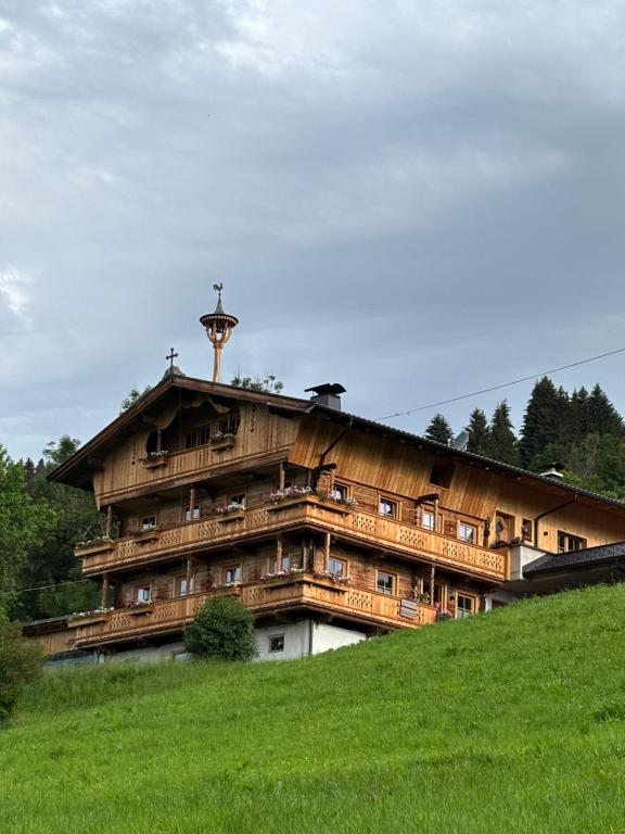 a large building on top of a green hill at Apartment Bichlhof in Brixen im Thale