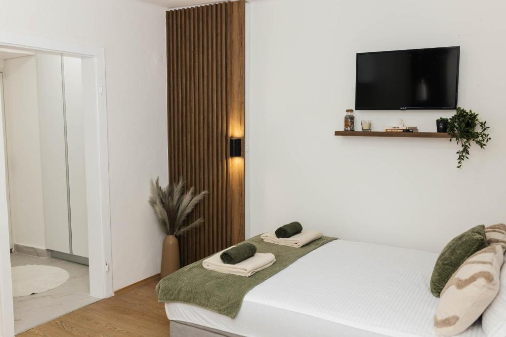 a bedroom with a bed with a tv on the wall at Lorena 21 Central in Bileća