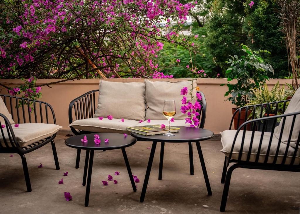 a couch and two chairs and a table with a glass of wine at Garden Studio in Pātan