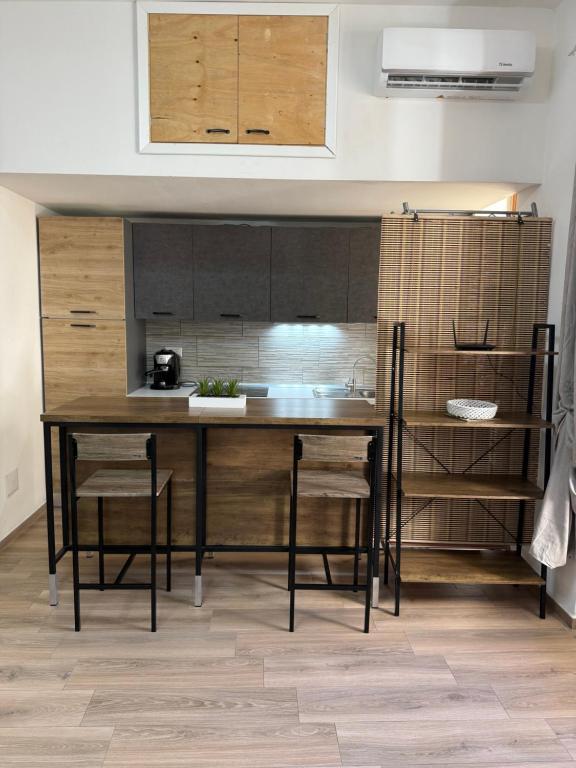 a kitchen with a table and chairs in a room at Sa Domitta due Alghero in Alghero