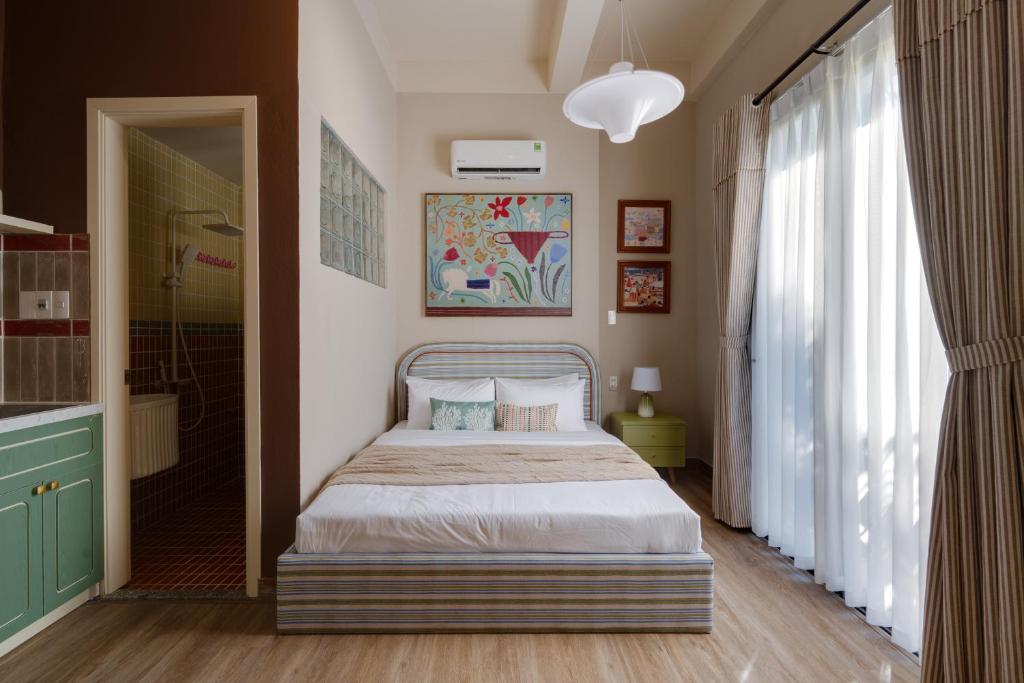 a bedroom with a bed and a large window at LangX Chapter Hotel & Apartment in Danang