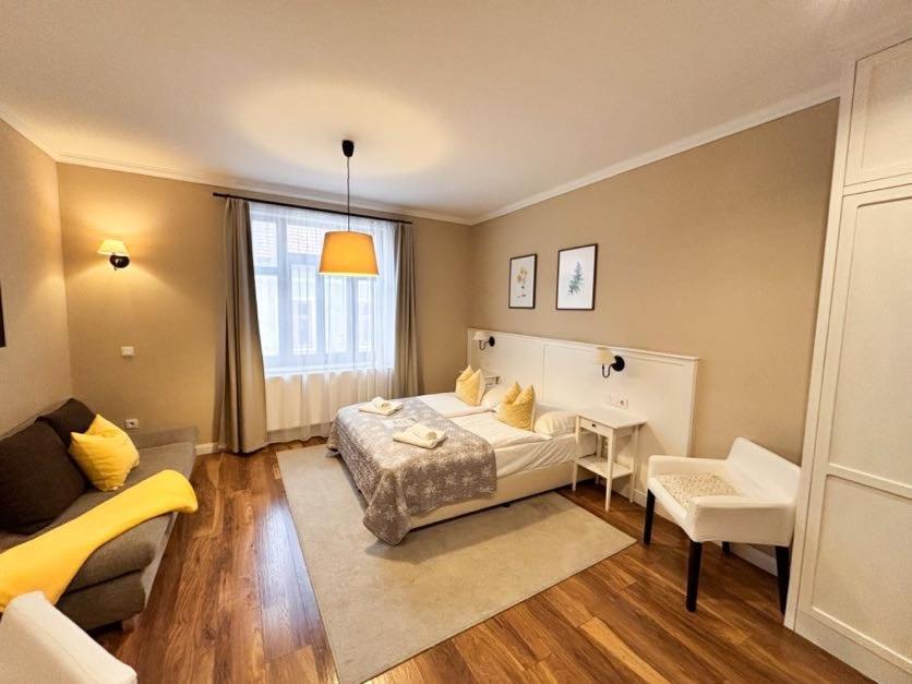 a bedroom with a bed and a couch and a desk at Erhardt Superior Rooms in Sopron