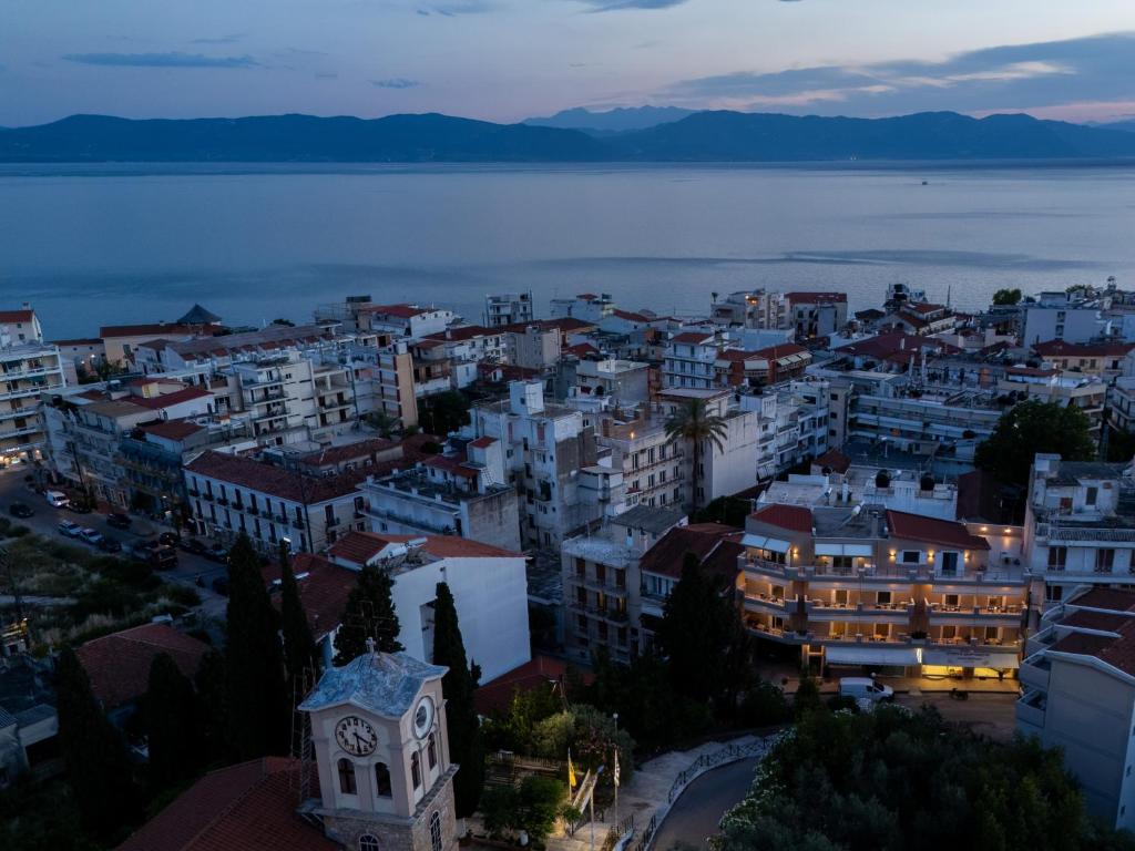 a view of a city at night with the water at TRIANTAFYLLOY ROOMS in Loutra Edipsou