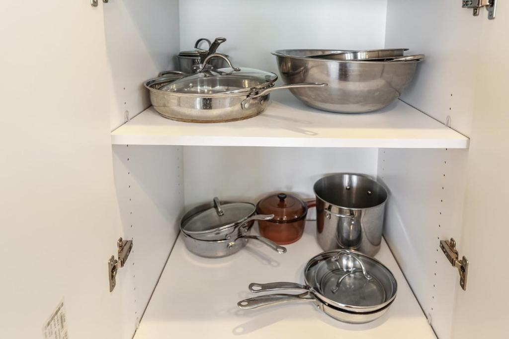 a row of pots and pans on a shelf in a kitchen at Sea Glass Villa in Oceanside