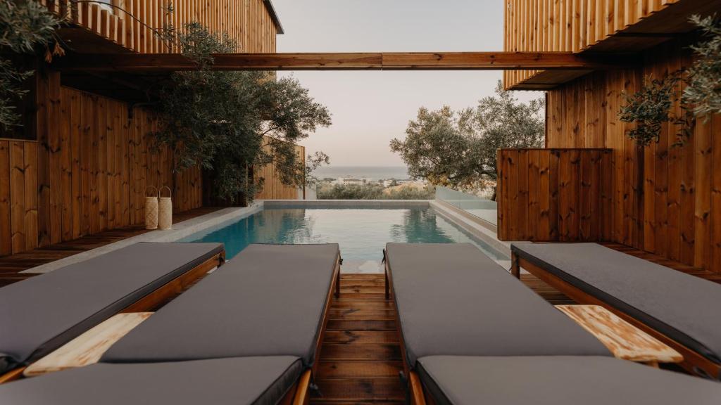 a swimming pool with two beds in a building at Zante Calinica Hotel in Tsilivi