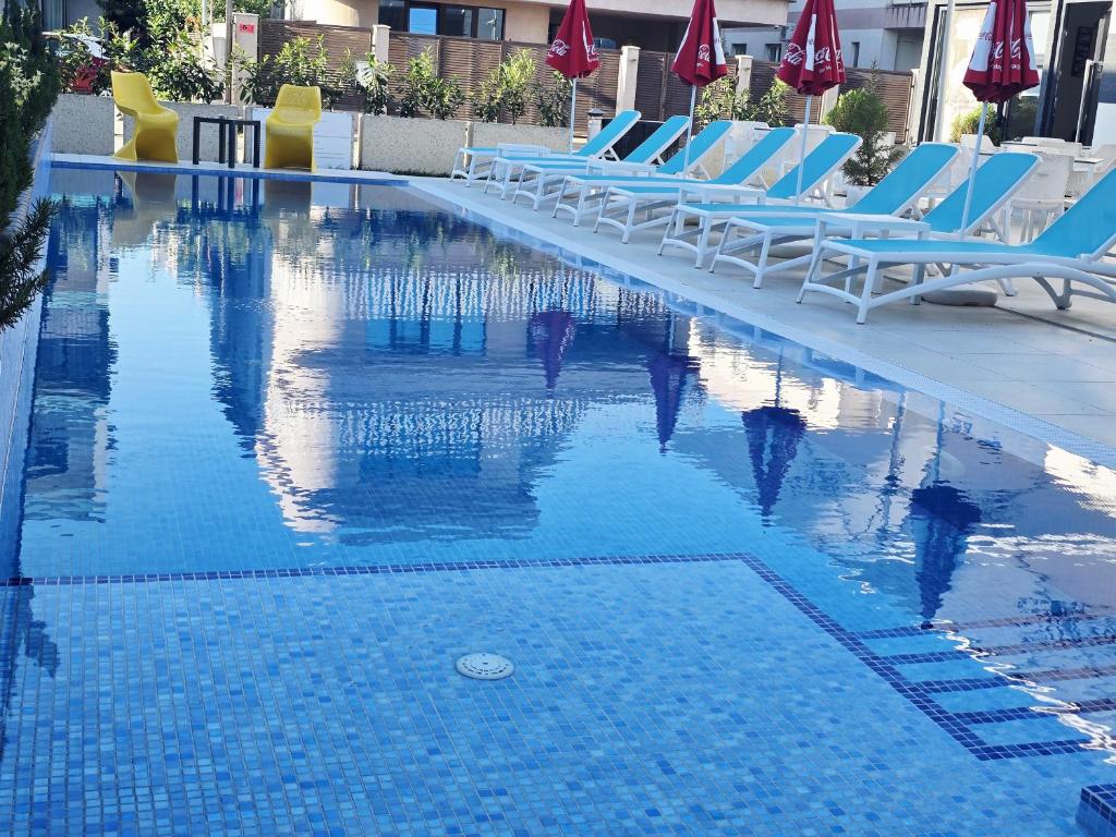 a swimming pool with lounge chairs and umbrellas at Bunga Bunga Resort Mamaia Nord in Mamaia Sat/Năvodari