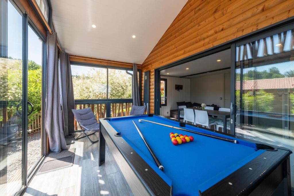 a pool table in a room with a balcony at Chalet L'entékia - Billard et Spa in Corcieux