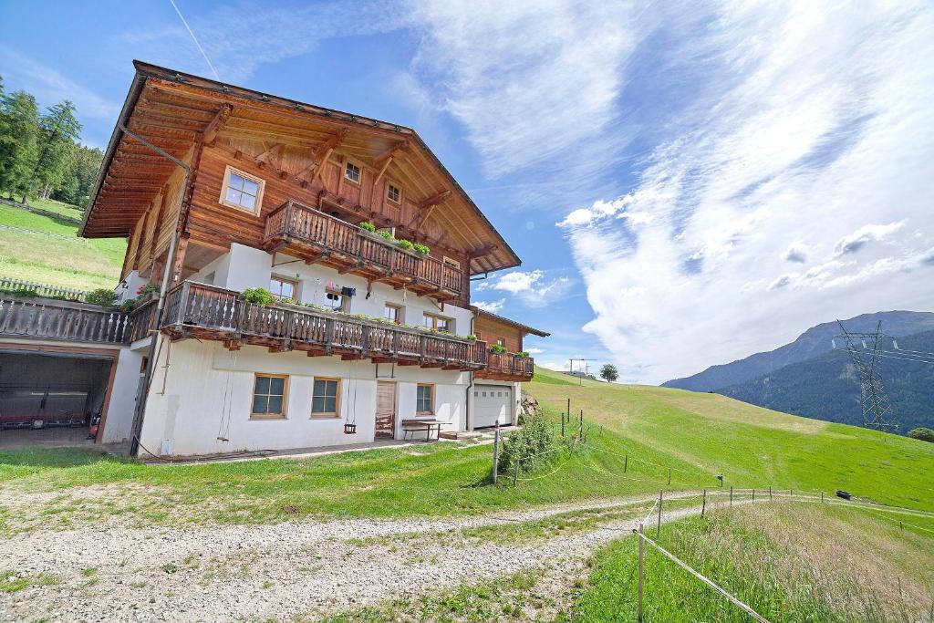 a house with a wooden roof on a hill at Innerdurachhof in Santa Valpurga