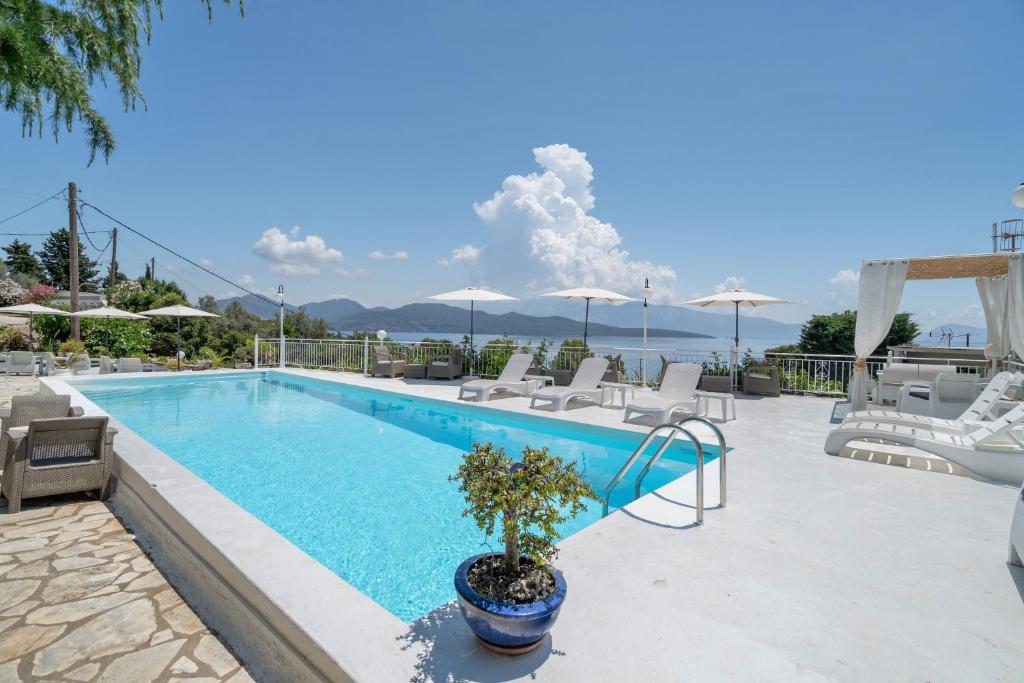 a swimming pool with chairs and a table at Xenia & Antonis in Nikiana