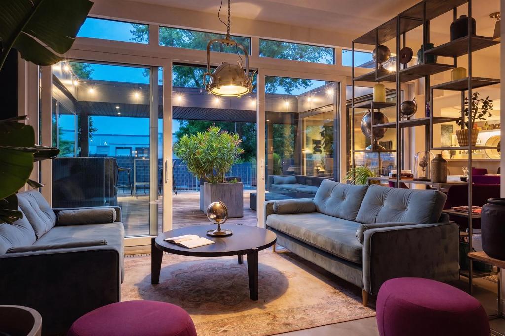 a living room with two couches and a table at MICE Collection Hotel Trier Business- und Stadthotel an der Mosel nahe SWT Arena und Viking Anleger in Trier